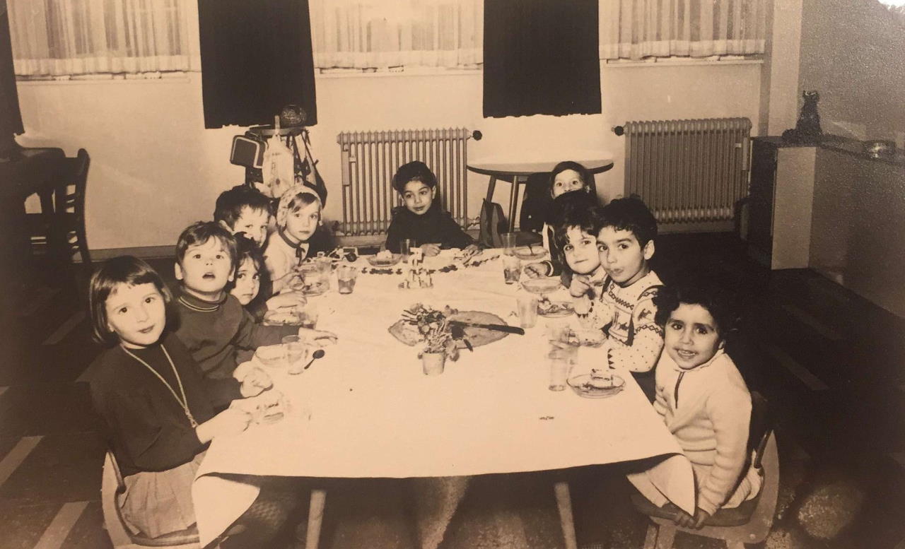 Foto mehrerer persisch-jüdischer Kinder, die an einem Tisch sitzen